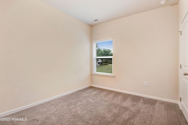 spare room featuring carpet floors, baseboards, and visible vents