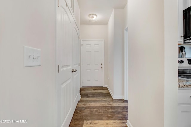 hallway featuring dark wood finished floors and visible vents
