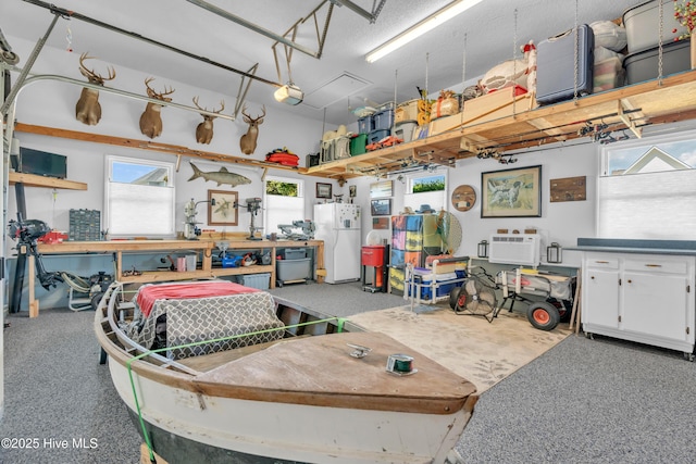 515 Blue Heron Dr, Newport, NC 28570 - garage featuring freestanding refrigerator, a garage door opener, a workshop area, and an AC wall unit