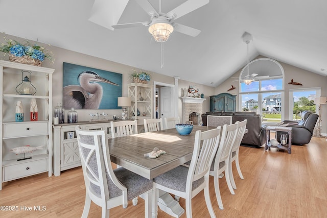 515 Blue Heron Dr, Newport, NC 28570 - dining space with a ceiling fan, vaulted ceiling, light wood finished floors, and a brick fireplace