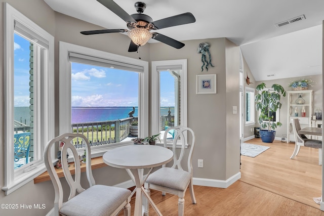 515 Blue Heron Dr, Newport, NC 28570 - dining area featuring light wood finished floors, a water view, a ceiling fan, baseboards, and vaulted ceiling