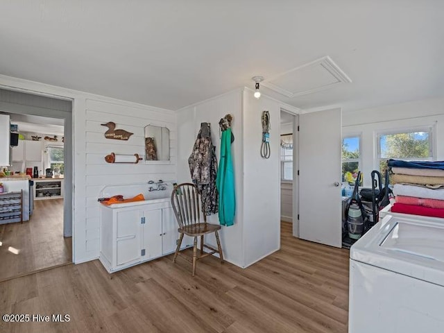 washroom featuring laundry area, light wood-style flooring, attic access, and a wealth of natural light
