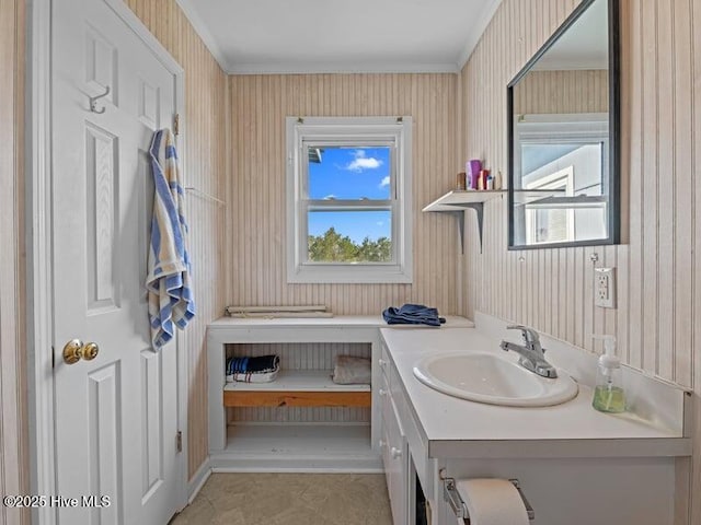 bathroom with vanity, crown molding, and wallpapered walls