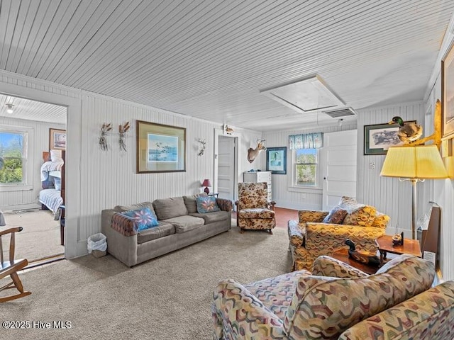 carpeted living room featuring attic access, wood ceiling, visible vents, and a healthy amount of sunlight