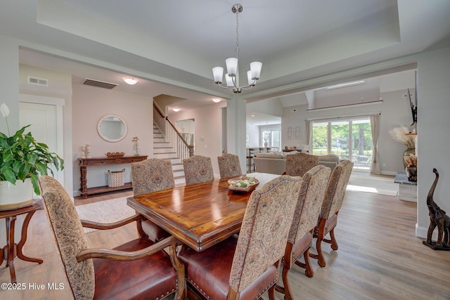 237 Pine Village Dr, Rocky Point, NC 28457 - dining room with a chandelier, light wood finished floors, stairs, and a tray ceiling
