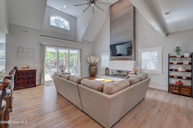 237 Pine Village Dr, Rocky Point, NC 28457 - living area with high vaulted ceiling, a fireplace, a ceiling fan, light wood-type flooring, and plenty of natural light