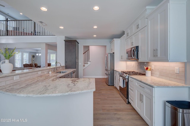237 Pine Village Dr, Rocky Point, NC 28457 - kitchen with appliances with stainless steel finishes, backsplash, light stone counters, light wood-style floors, and recessed lighting
