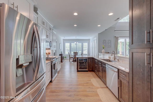 237 Pine Village Dr, Rocky Point, NC 28457 - kitchen with stainless steel appliances, beverage cooler, light wood finished floors, recessed lighting, and light stone counters