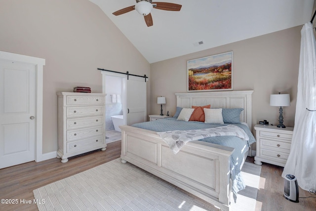 237 Pine Village Dr, Rocky Point, NC 28457 - bedroom with a barn door, light wood finished floors, high vaulted ceiling, connected bathroom, and ceiling fan