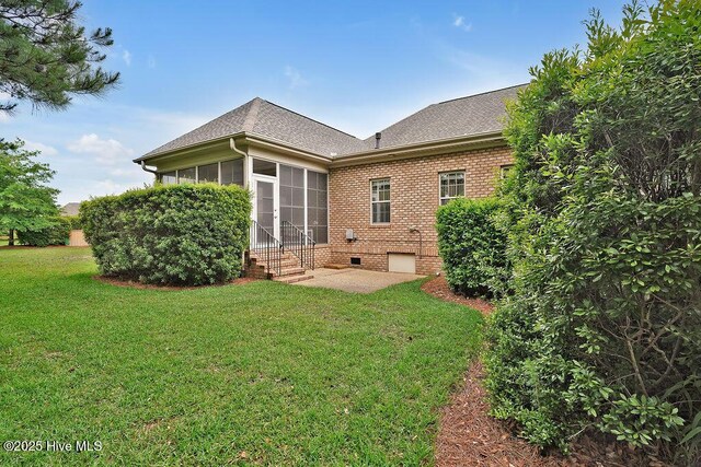 3284 Gardenwood Dr, Leland, NC 28451 - back of property featuring a patio, a yard, roof with shingles, brick siding, and a sunroom