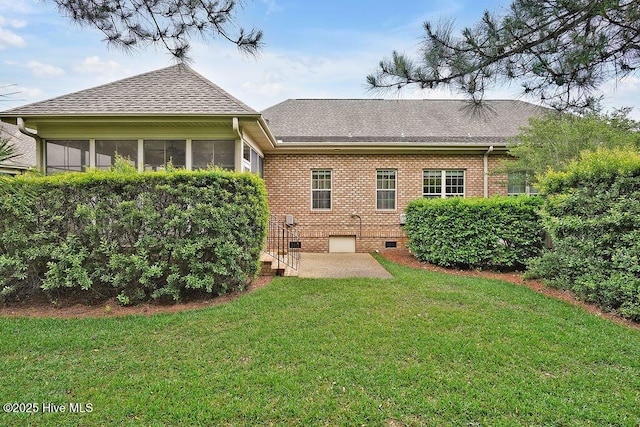 3284 Gardenwood Dr, Leland, NC 28451 - rear view of house with roof with shingles, a patio, a yard, brick siding, and a sunroom