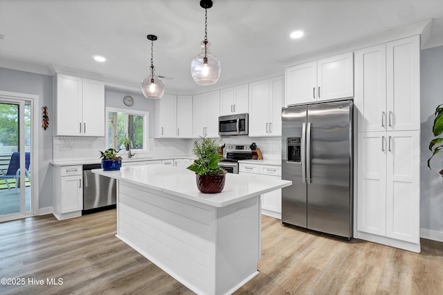 kitchen with stainless steel appliances, light countertops, a sink, plenty of natural light, and recessed lighting