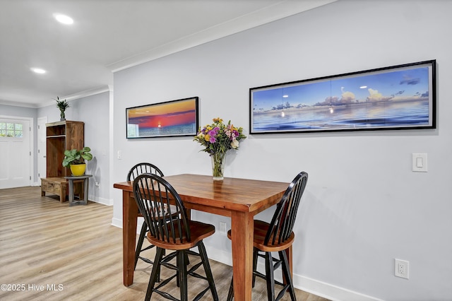 dining room with ornamental molding, baseboards, light wood finished floors, and recessed lighting