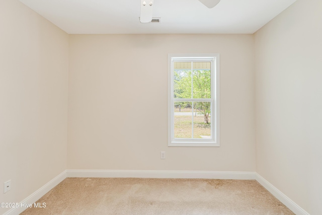empty room featuring baseboards, ceiling fan, and carpet