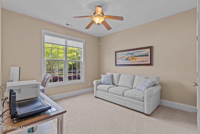 carpeted home office featuring baseboards and ceiling fan