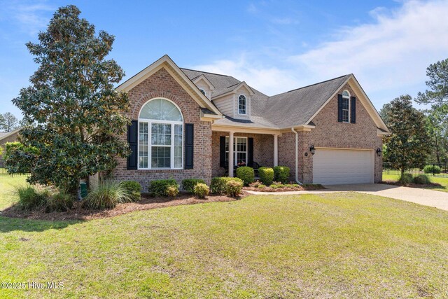 view of front of home with brick siding, an attached garage, concrete driveway, and a front lawn
