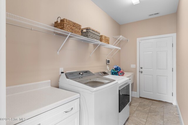 laundry area with washer and dryer and baseboards