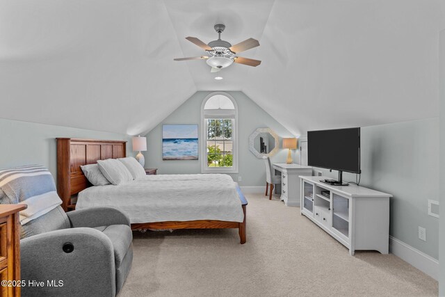 bedroom with vaulted ceiling, light colored carpet, ceiling fan, and baseboards