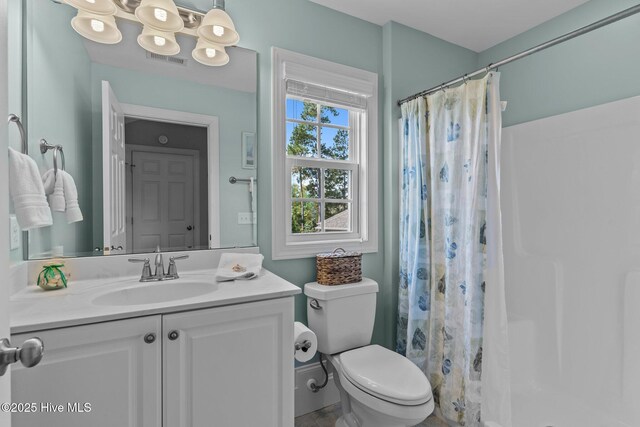 bathroom with a shower with shower curtain, vanity, and toilet