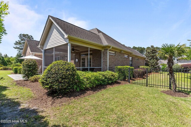 view of side of property with brick siding, a ceiling fan, a sunroom, and a shingled roof