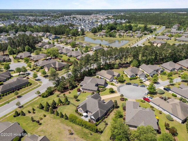 aerial view of property and surrounding area featuring a nearby body of water and nearby suburban area