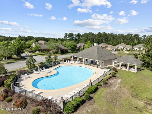 community pool featuring a pergola, view of wooded area, and a patio area