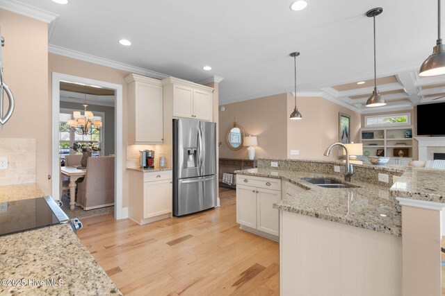 kitchen featuring stainless steel refrigerator with ice dispenser, a sink, ornamental molding, recessed lighting, and backsplash