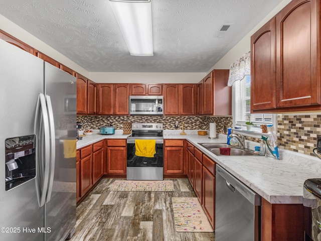 102 Flat Rock Ln, Richlands, NC 28574 - kitchen with stainless steel appliances, a sink, light countertops, dark wood-type flooring, and a textured ceiling