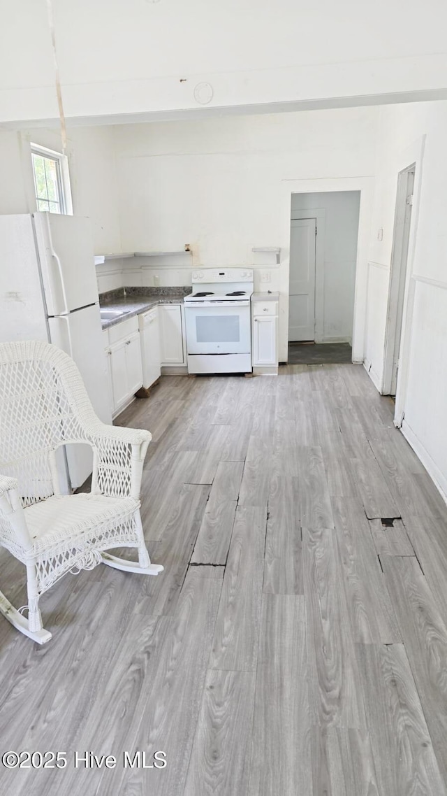 kitchen with white appliances, white cabinets, and light wood-style flooring
