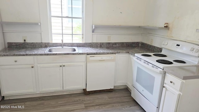 kitchen featuring white appliances, a sink, white cabinets, and wood finished floors