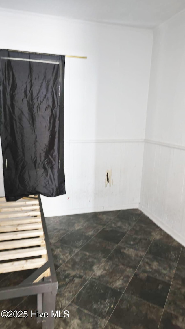spare room with a wainscoted wall