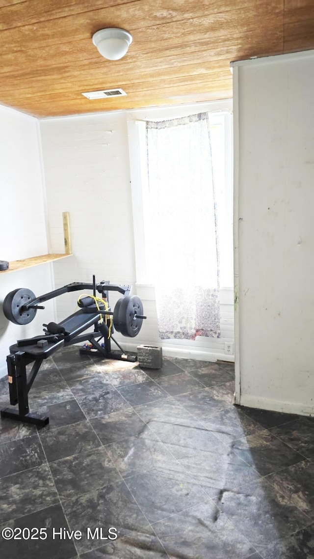 workout room featuring wood ceiling and baseboards