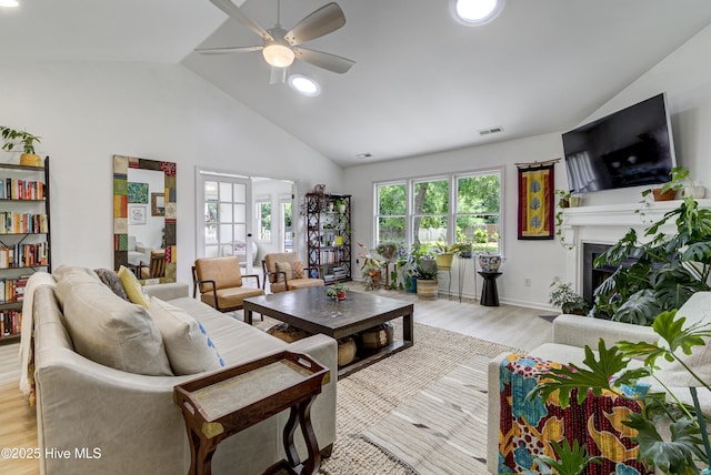 living area with a ceiling fan, light wood-style flooring, a fireplace, recessed lighting, and high vaulted ceiling