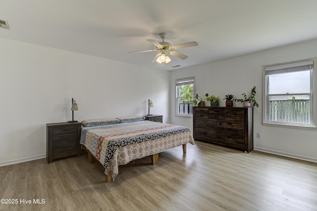 bedroom featuring light wood-style floors, baseboards, and ceiling fan