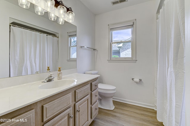 full bath featuring wood finished floors, toilet, baseboards, and vanity