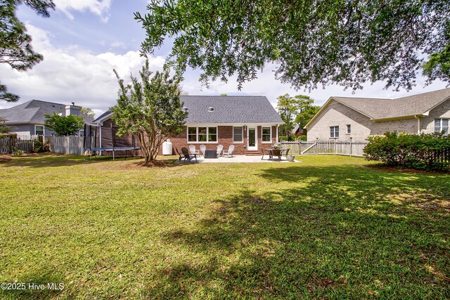 rear view of property with a patio, brick siding, and a trampoline