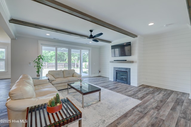 374 Yucca Ln, Wilmington, NC 28412 - living area featuring wood finished floors, beam ceiling, ceiling fan, crown molding, and a glass covered fireplace