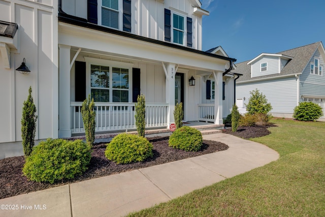 374 Yucca Ln, Wilmington, NC 28412 - entrance to property with board and batten siding, covered porch, and a yard