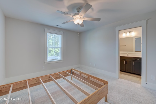 374 Yucca Ln, Wilmington, NC 28412 - unfurnished bedroom with light carpet, a sink, connected bathroom, baseboards, and a ceiling fan