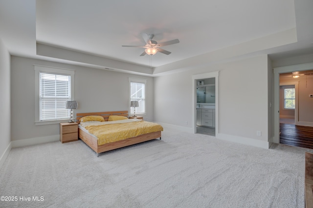 374 Yucca Ln, Wilmington, NC 28412 - carpeted bedroom with a raised ceiling, baseboards, ensuite bathroom, and ceiling fan