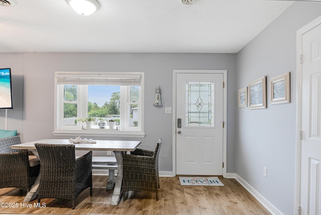 dining room with light wood-type flooring and baseboards
