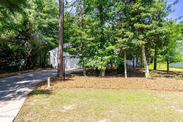 103 Arborvitae Ct, Pine Knoll Shores, NC 28512 - view of front of house featuring driveway, a front yard, a garage, and an outbuilding