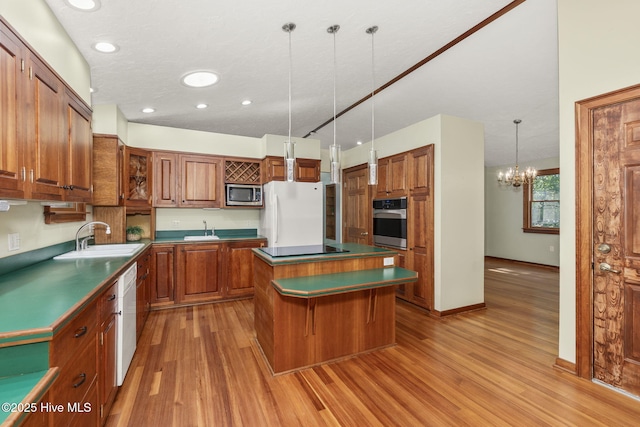 103 Arborvitae Ct, Pine Knoll Shores, NC 28512 - kitchen with stainless steel appliances, brown cabinetry, a kitchen island, light wood finished floors, and recessed lighting