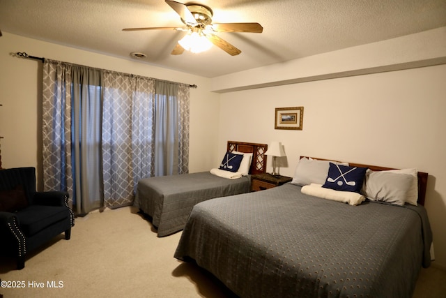 bedroom featuring carpet, a ceiling fan, and a textured ceiling