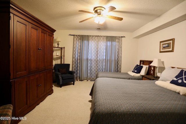 bedroom with light carpet, ceiling fan, and a textured ceiling
