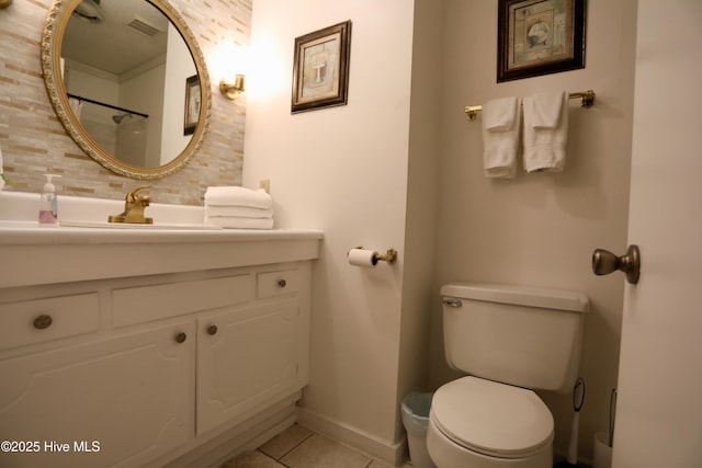 bathroom with tile patterned flooring, toilet, baseboards, vanity, and backsplash