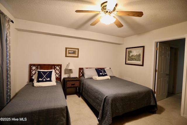 bedroom with carpet flooring, ceiling fan, and a textured ceiling