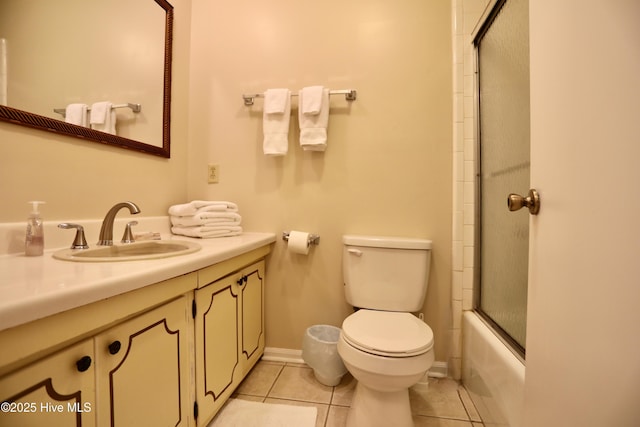 bathroom featuring toilet, tile patterned floors, vanity, and enclosed tub / shower combo