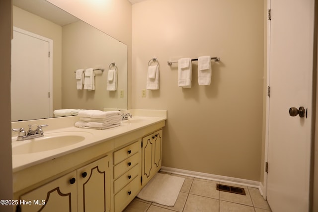full bathroom featuring tile patterned flooring, double vanity, and baseboards