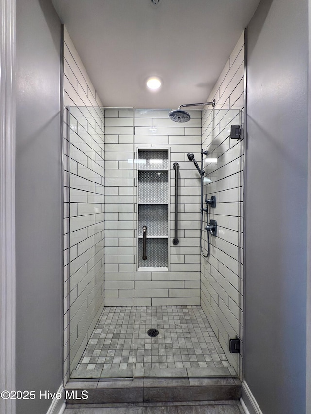 bathroom with baseboards and a stall shower